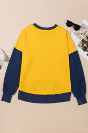 Yellow crewneck sweatshirt with contrast navy blue sleeves and hem.